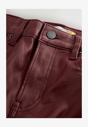 Burgundin keinonahkafarkut, joissa on sileä pinta, varustettu metalliset nappisuljenta, etutaskut ja kontrastiväriset ompelutiedot.