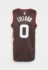 Maglia NBA marrone con accenti rossi, che presenta il nome "LILLARD" e il numero "0" in bianco. Tessuto testurizzato con strisce multicolori sui lati.