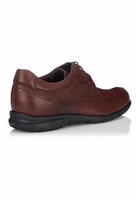 Zapato de cuero marrón con punta redonda, diseño de cordones, costuras en contraste y suela de goma negra texturizada. Presenta un pequeño logo cerca del talón.