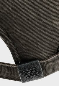 Brązowa czapka z korduru, charakteryzująca się teksturowanym materiałem, solidnymi szwami i metalowym zapięciem z logo "Camel Active".