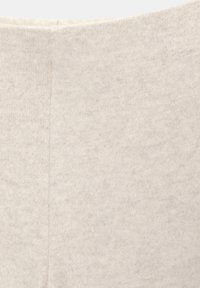 Tissu beige clair avec une texture douce et un motif chiné subtil, présentant une finition lisse et des bords légèrement effilés.