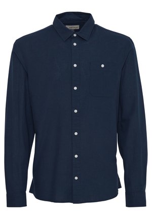 Marineblaues Langarmhemd aus Leinen. Mit durchgehender Knopfleiste, einer einzelnen Brusttasche und weißen Knöpfen als Kontrast. Glatte Textur.