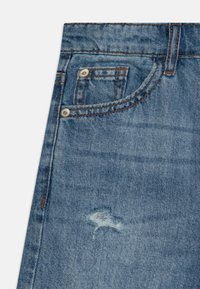 Blå denimjeans med en lett falmet finish, med en liten slitt lapp og kontrastsøm på lommene og midjen.