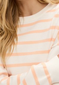 Leichter Pullover aus weichem Material mit horizontalen Streifen in Pastellorange und Creme. Er hat einen Rundhalsausschnitt und eine lässige Passform.