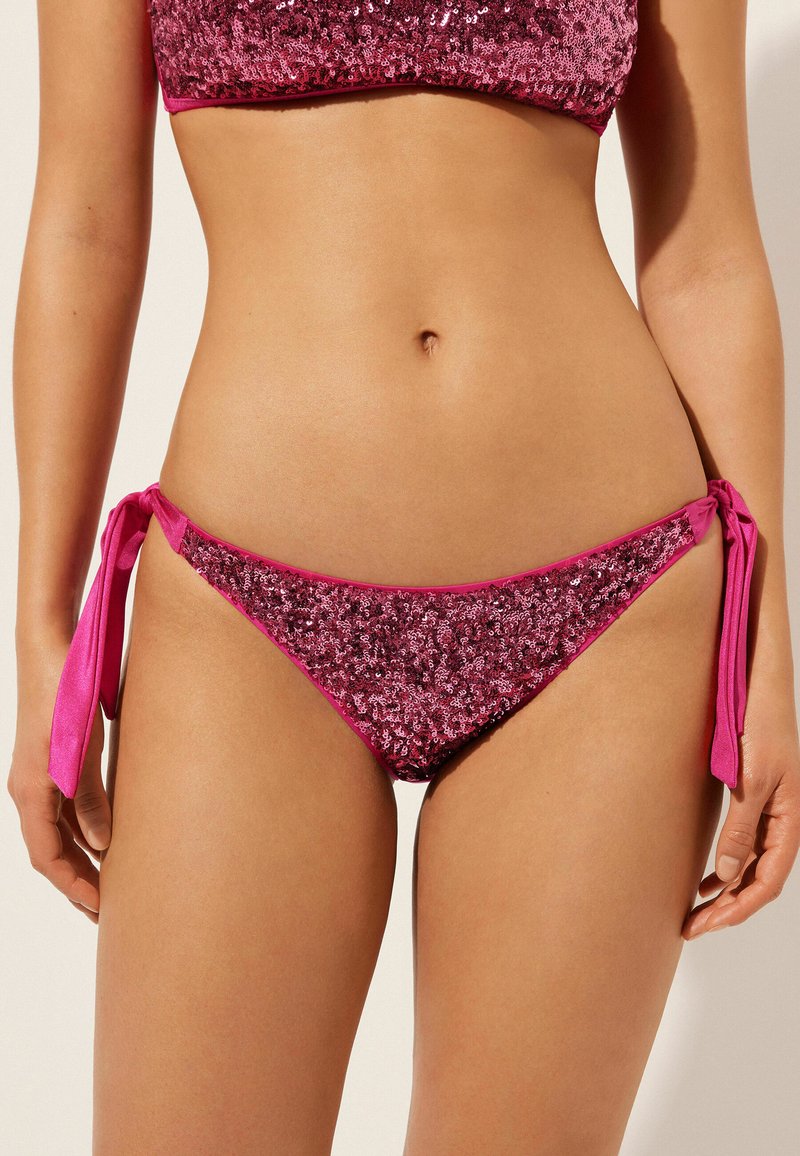 Rosa bikinitrosa med paljettdetaljer. Har knytband på båda sidor. Mjuk textur med låg midja.