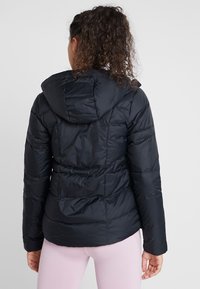 Czarna pikowana kurtka puchowa z kapturem, z przeszyciami i taliowanym krojem. Wykonana z błyszczącego, gładkiego materiału.