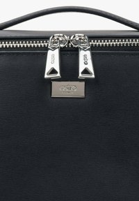 Černá kožená kabelka se stříbrným zipem s dvojím táhlem a obdélníkovou kovovou destičkou s vyraženým názvem značky.