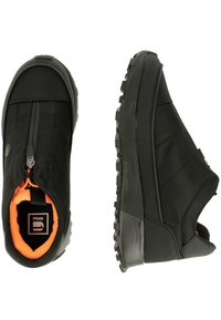 Svarta slip-on skor med ett texturerat tygöverdrag, gummisula och orange foder. Har en framdragkedja för enkel på- och avtagning och en vadderad krage.