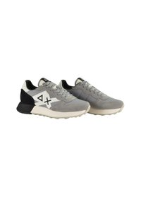 Sneaker sportive grigie realizzate con una combinazione di materiali in suede e mesh, con logo ricamato e dettagli neri a contrasto sul tallone.