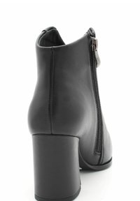 Czarne skórzane botki za kostkę z okrągłym noskiem, tylnym zamkiem błyskawicznym i słupkowym obcasem. Powierzchnia ma gładką teksturę i minimalne detale.