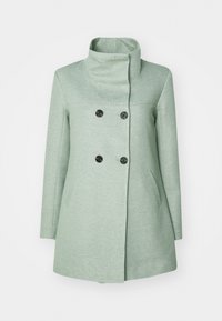 Abrigo verde menta con cuello alto, frontal de doble botonadura, botones negros y bolsillos laterales. Fabricado con una tela texturada.