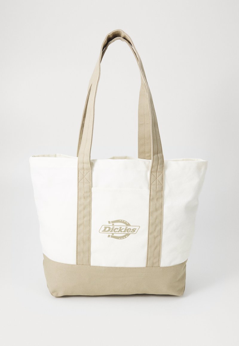Kremfarget kanvas totebag med beige bunn, doble håndtak og frontlomme. Har et trykt logo på forsiden. Robust og romslig design.