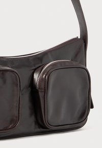 Dark brown leather shoulder bag featuring two square pockets, a zippered main compartment, smooth texture, and a sleek design.