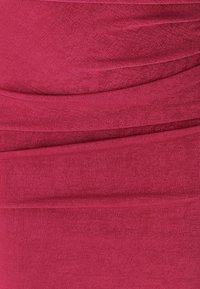 Burgundy knit fabric with a textured finish. Features horizontal ruching and smooth surface with slight shine. Upper edge is folded.
