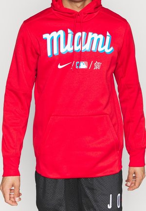 Roter Hoodie mit "miami" Text, Nike, MLB und Miami Marlins Logos auf der Brust, getragen von einer Person in schwarzen Shorts.