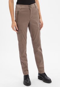 Pantalons cargo en tissu marron clair avec une coupe slim, dotés de poches zippées et de subtils accents en métal. Texture lisse et design fuselé.