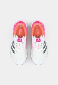 Scarpe sportive bianche con strisce nere, dettagli rosa e una tomaia in rete testurizzata. Presentano una soletta rosa ammortizzata con marchio.