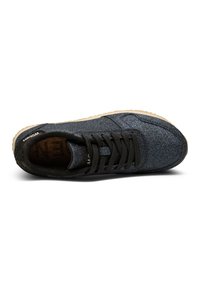 Baskets noires et bleues avec une tige texturée et pailletée, des lacets noirs et une semelle de couleur claire. Elles disposent d'un intérieur rembourré pour le confort.