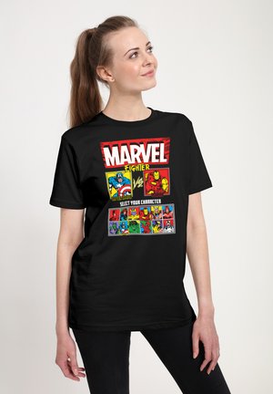 Woman wearing black Marvel Fighter t-shirt featuring Captain America and Iron Man versus screen and character selection grid.
