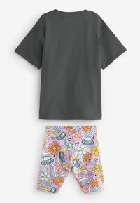 Dwuczęściowy zestaw składający się z ciemnoszarego bawełnianego t-shirtu oraz pastelowych różowych legginsów z kolorowym, kwiatowym i fantazyjnym wzorem.