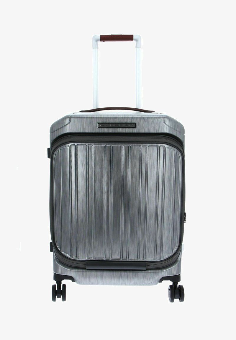 Valigia rigida grigia con scanalature verticali, cerniera nera, due ruote lisce e manico telescopico con un accento bordeaux.