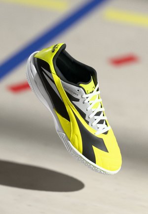 Yellow and black sports shoe with a textured upper, white laces, and a rubber sole. Features a streamlined design and contrasting color accents.