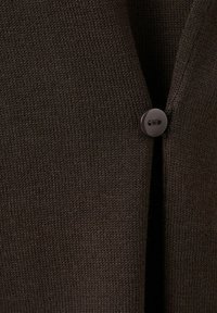 Donkerbruin gebreide stof met een enkele ronde donkerbruine knoop in het midden vastgemaakt, met verticale textuurdetails.