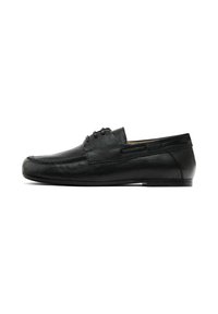 Mocassins en cuir noir avec une texture lisse, présentant un profil bas et de subtils détails de surpiqûres. S'enfilent facilement avec un minimum de matériel.
