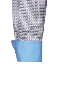 Manica di camicia a fantasia con un design geometrico in blu, arancione e bianco, con un polsino azzurro chiaro e una texture liscia.