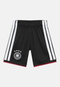 Calças de treino pretas com riscas laterais brancas, detalhes em vermelho e um emblema da federação alemã de futebol com cinco estrelas e uma águia.