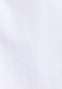 Tessuto bianco con una trama fine ed uniforme. Il materiale appare liscio e leggero, con un colore costante e chiaro in tutta la superficie.