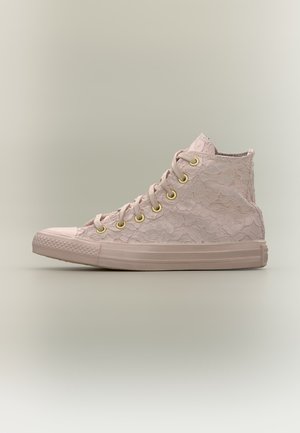 Ανοιχτό ροζ ψηλό sneaker με φλοράλ δαντελένια υφή, χρυσά οπές και καουτσούκ σόλα σε ουδέτερο φόντο.
