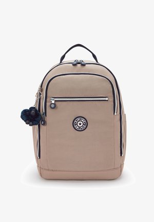 Zaino beige dalla texture liscia, con tasca frontale, accenti navy a contrasto e portachiavi con pon pon blu. Logo Kipling visibile.