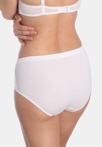 Witte katoenen high-waisted onderbroeken met een zachte textuur, elastische tailleband en minimale naden, met een close-up van de achterkant.