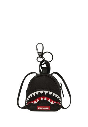 Portachiavi mini zaino nero con zip, design denti di squalo in rosso, bianco e nero, e clip e anelli neri.