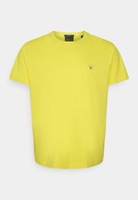 Geel katoenen T-shirt met een ronde hals en korte mouwen; heeft een klein logodetail op de borst. Regular fit, soepele textuur.