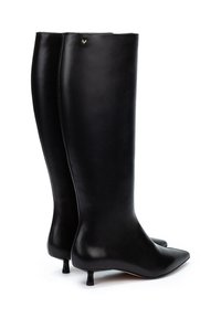 Botas de cuero negras hasta la rodilla con punta afilada, silueta esbelta y tacón kitten. Un detalle dorado cerca de la parte superior añade un toque sutil.