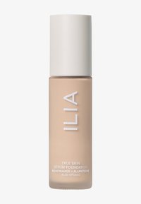 ILIA True Skin Serum Foundation i en frostad beige glasflaska med ett vitt pumplock. Texten på flaskan inkluderar produktinformation och ingredienser.