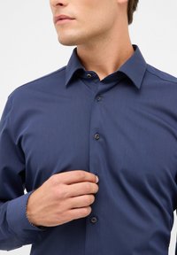 Navyblauw button-up shirt van een gladde stof, met een spitse kraag en contrasterende, geruite manchetten, voorzien van bruine knopen.