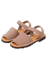 Ruske nahkalenzi, avatud varvastega, ristuvad rihmad ja õmblusega äär, mis puhkavad tekstuurse viimistlusega kummitaldadel.