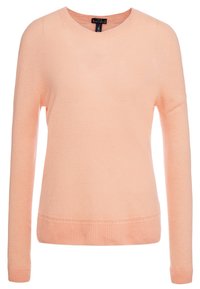 Ljus persikofärgad tröja med rund halsringning, tillverkad av mjukt, texturerat tyg, med långa ärmar och ribbade detaljer vid ärmslut och fåll.