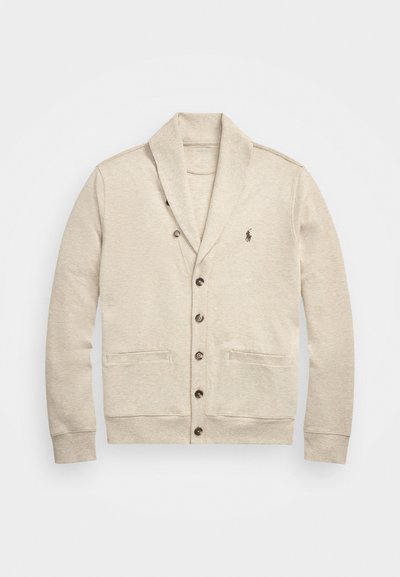 Jasno beżowy kardigan, miękki materiał, kołnierz szalowy, trzy guziki, dwie przednie kieszenie oraz haftowane logo na lewej piersi.