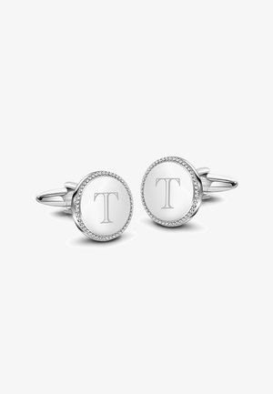 Srebrne spinki do mankietów o okrągłym kształcie, z teksturowanym brzegiem i wygrawerowanym "T" na gładkiej powierzchni, ozdobione małymi kamieniami.