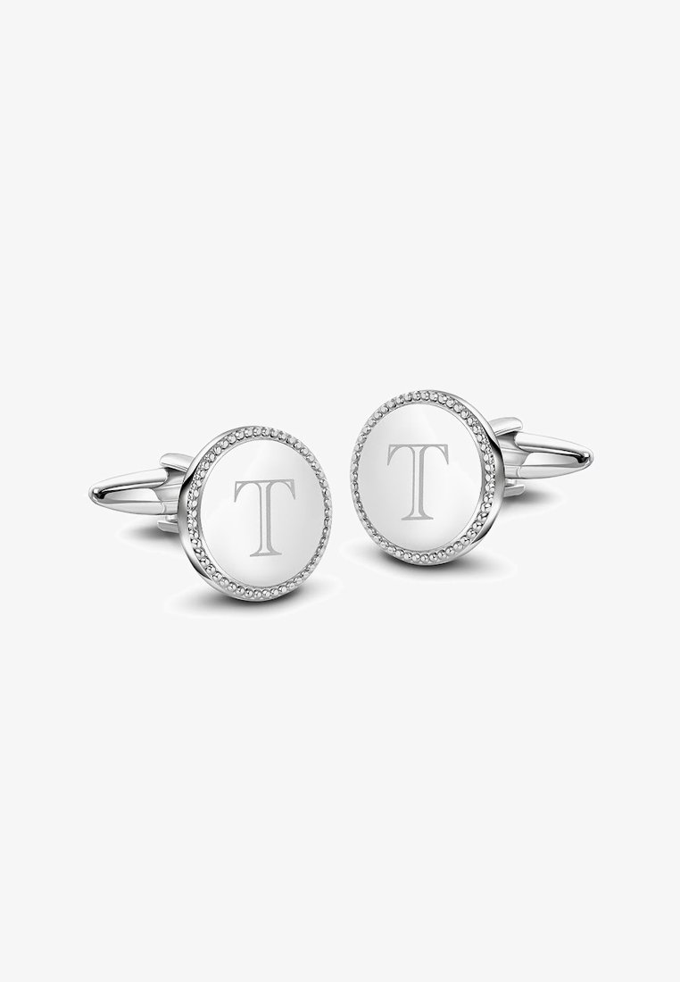 Srebrne spinki do mankietów o okrągłym kształcie, z teksturowanym brzegiem i wygrawerowanym "T" na gładkiej powierzchni, ozdobione małymi kamieniami.