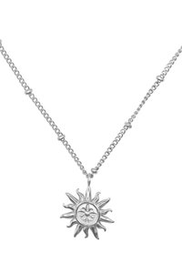Srebrny naszyjnik z wisiorkiem w kształcie słońca, posiadający centralny emblemat i promieniujące promienie, zawieszony na delikatnym łańcuszku z okrągłymi ogniwami.