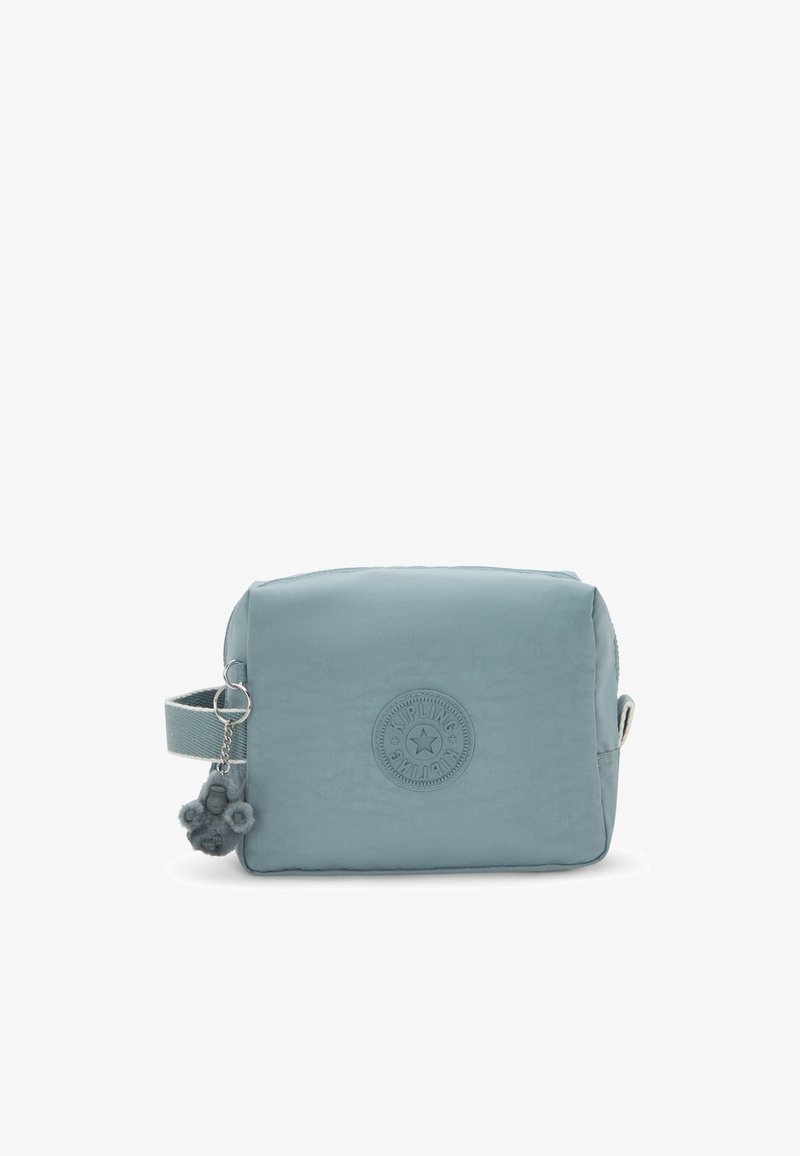 Borsa in tessuto morbido di colore blu chiaro con chiusura a zip, patch con logo rotondo, manico laterale e charm peloso attaccato. Forma rettangolare con texture liscia.