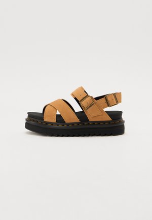 Tan suede platform sandals with two adjustable straps, black textured rubber sole, and yellow stitching along the edge.