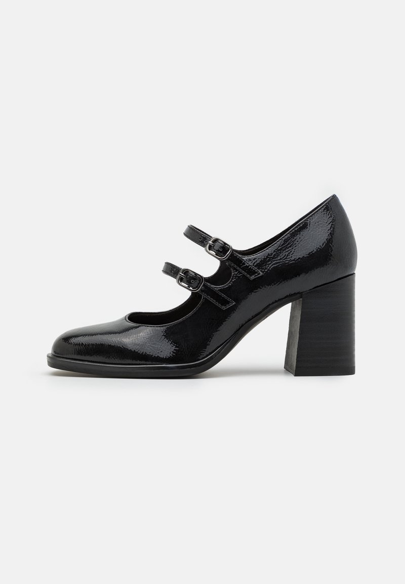 Chaussure Mary Jane en cuir verni noir avec deux brides à boucles et un talon bloc épais sur fond blanc.