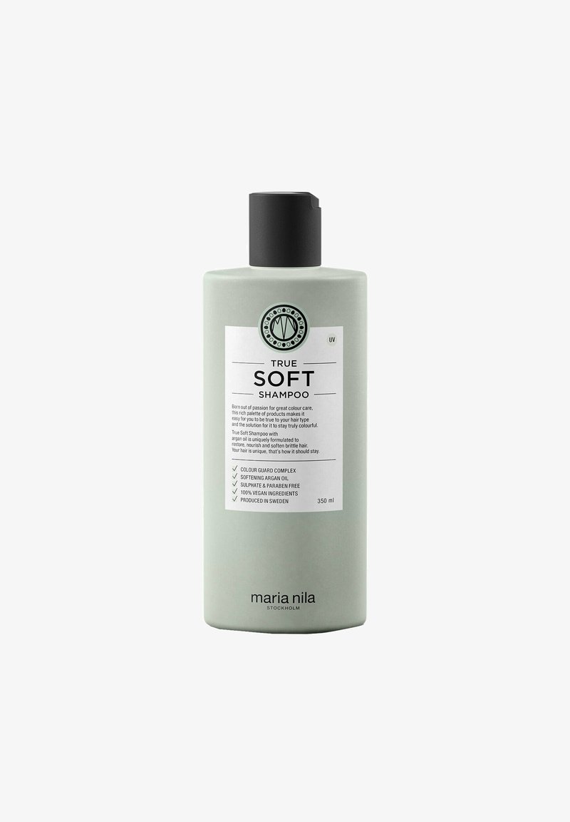 Groene cilindervormige shampoofles met een zwarte dop. Etiket bevat de productnaam "TRUE SOFT" en details over de voordelen van de ingrediënten. 350 ml.