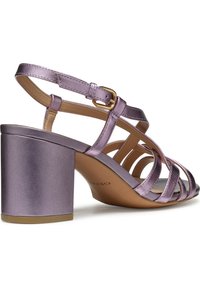 Sandal con tacco alto metallico viola, con più cinturini, forma quadrata e tacco a blocco. Presenta una fibbia in tonalità dorata e una texture liscia.